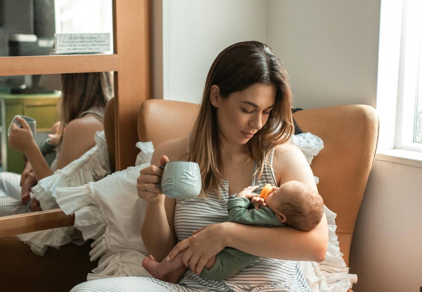 Mother cradling newborn in a cozy indoor setup. Perfect family and lifestyle theme.